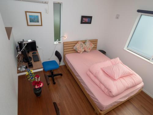 a small bedroom with a pink bed and a desk at Kamakura International House Double Room w Shower Toilette Min 1 female guest - Vacation STAY 11403 in Kamakura