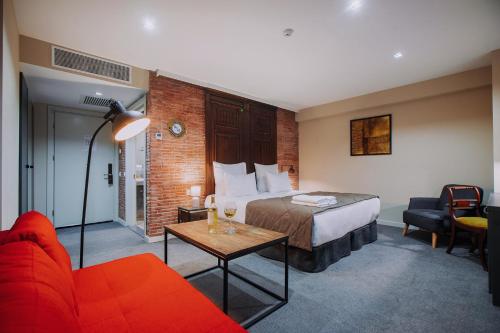 a hotel room with a bed and a red couch at TbiliSee Hotel in Tbilisi City