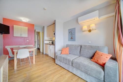 un salon avec un canapé gris et une table dans l'établissement IMMOGROOM - 2 Rooms sea view - Swimming pool - Terrace - Parking - AC, à Cannes