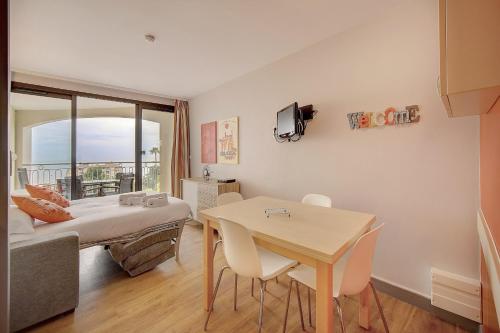 une chambre avec un lit et une table avec des chaises dans l'établissement IMMOGROOM - 2 Rooms sea view - Swimming pool - Terrace - Parking - AC, à Cannes