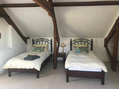 two twin beds in a room with a attic at St Michaels House in Crediton