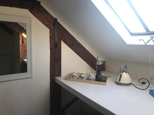 een kamer met een dakraam en een tafel met een spiegel bij St Michaels House in Crediton