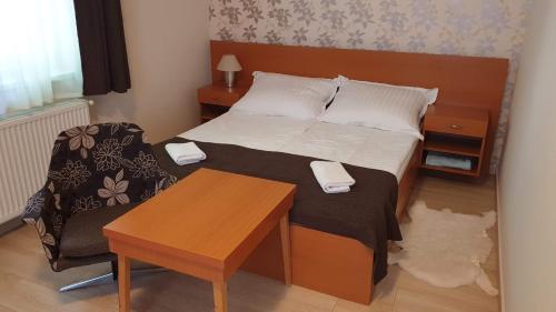 a small bedroom with a bed and a table at Keller Apartmanok in Hajdúszoboszló