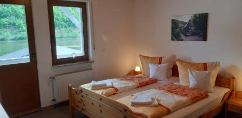 1 dormitorio con 2 camas y ventana en Altes Weingut Bröhl en Hatzenport