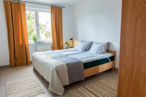 a bedroom with a large bed with a window at Apartamenty Starówka in Olsztyn