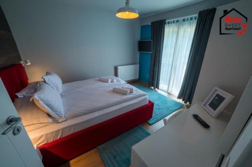 um pequeno quarto com uma cama e uma janela em Arca Sweet Apartment Ariniș em Gura Humorului