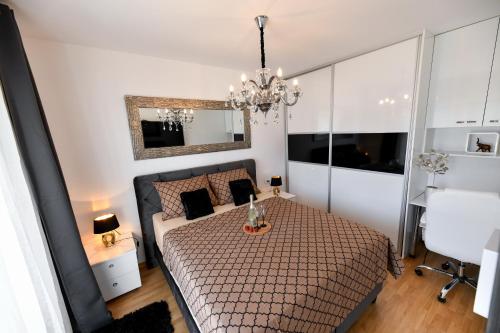 a bedroom with a bed and a chandelier at Lauris Luxury Apartment Zadar in Zadar