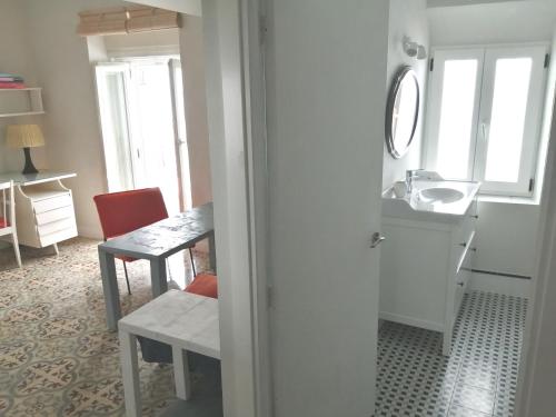 La salle de bains est pourvue d'un lavabo, d'une table, d'une table et d'une chaise. dans l'établissement El Patio de la Ballena, à Vejer de la Frontera