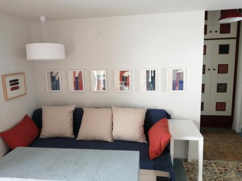 sala de estar con sofá azul y cuadros en la pared en El Patio de la Ballena en Vejer de la Frontera
