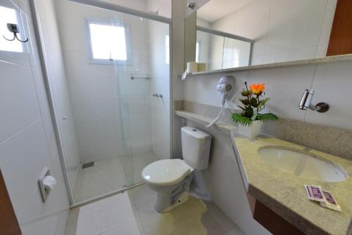 y baño con ducha, aseo y lavamanos. en Vinds Economic Hotel, en Ipatinga