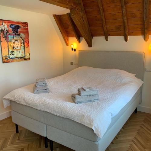 um quarto com uma cama com toalhas em The Harbour Leiden em Leiden