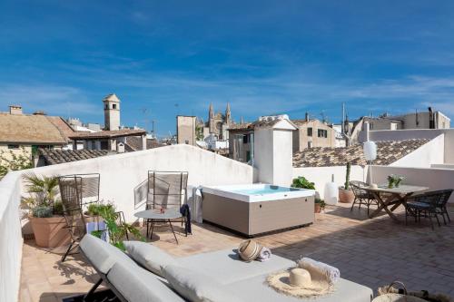 a patio with a couch and a table on a roof at Can Bordoy Grand House Hotel GL Preferred Hotel in Palma de Mallorca