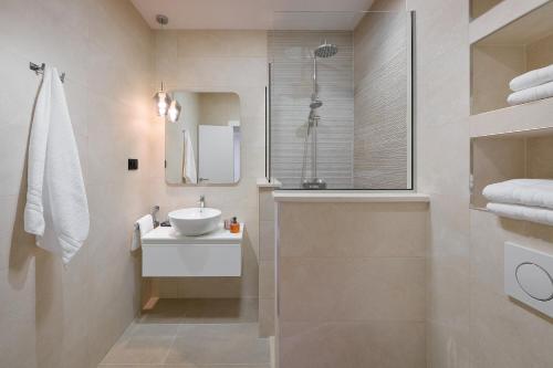 a white bathroom with a sink and a shower at Villa Allure in Sutivan