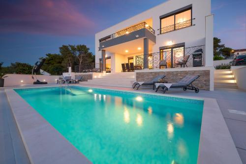 a house with a swimming pool in front of it at Villa Allure in Sutivan