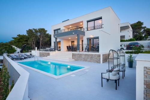 a villa with a swimming pool and a house at Villa Allure in Sutivan