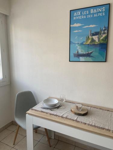 een eettafel met een foto aan de muur bij Studio Aix les Bains entre centre-ville et lac in Aix-les-Bains