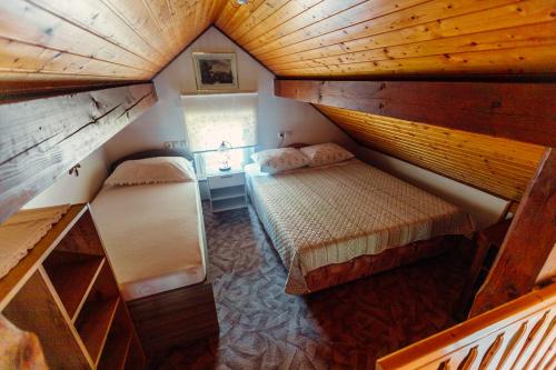 an attic bedroom with two beds in a room at Zidanica Bahor in Črnomelj