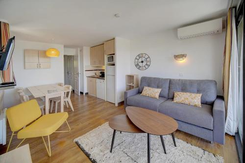 un salon avec un canapé bleu et une table dans l'établissement IMMOGROOM - 2 Rooms - Renovated - Pool - Parking - Air conditioning -, à Cannes