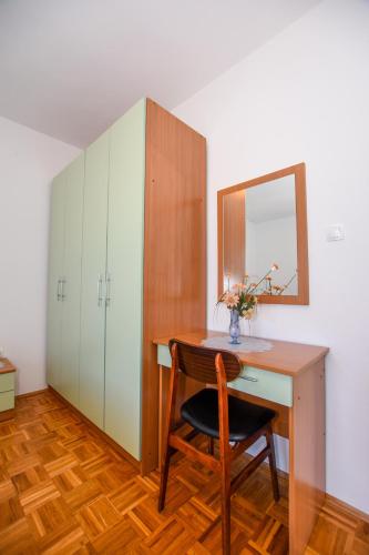 a desk with a mirror and a chair in a room at APARTMANI MARIJA LJUBICA in Pag