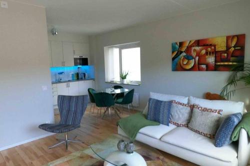 a living room with a white couch and a table at Homestay - private room in an apartment in Gothenburg