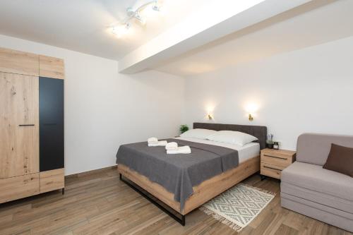 um quarto com uma cama e um sofá em Apartments Stipančić em Krk