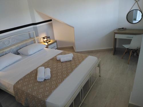 a bedroom with a bed with two pillows and a desk at Apartment 2 for rent in Tzanata Kefalonia in Dhimisianáta