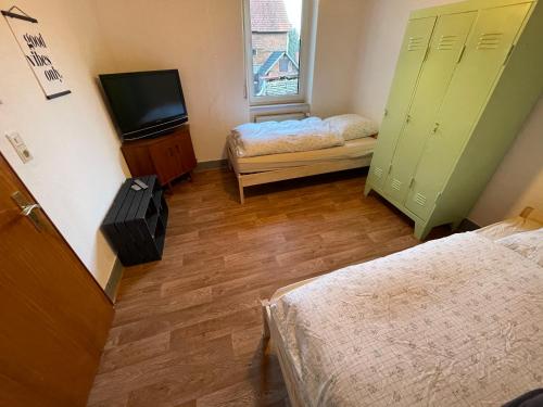 Kleines Zimmer mit 2 Betten und einem TV in der Unterkunft Das Baumeisterhaus - Monteurzimmer in Grünberg in Grünberg