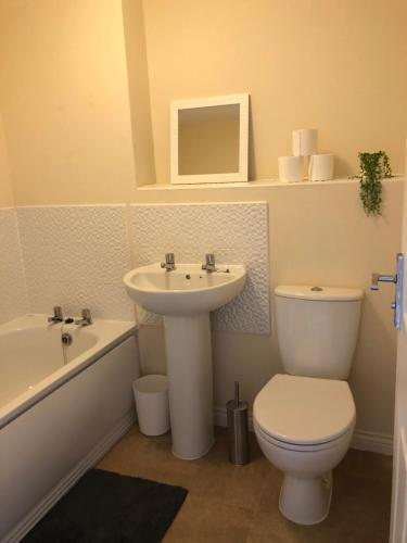 a bathroom with a sink and a toilet and a bath tub at Spring House - Staycation - Perfect for Contractors & Families - 2 Parking Spaces in Dudley