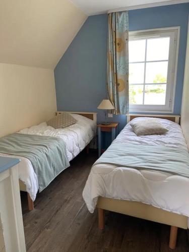 a bedroom with two beds and a window at Pepper Lake in Fort-Mahon-Plage