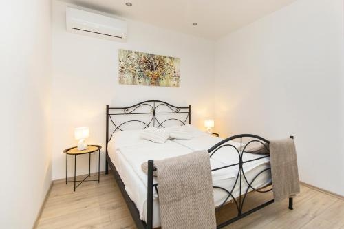 - une chambre avec un lit et deux tables de chevet dans l'établissement Apartman Lungo Mare, à Rabac