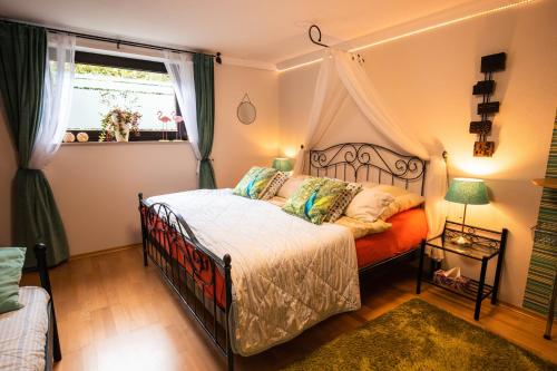 a bedroom with a canopy bed and a window at Erholungskellerchen in Bad Lippspringe