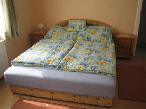 ハイドゥソボスローにあるKeller Vendégházのベッド(青い掛け布団、枕付)