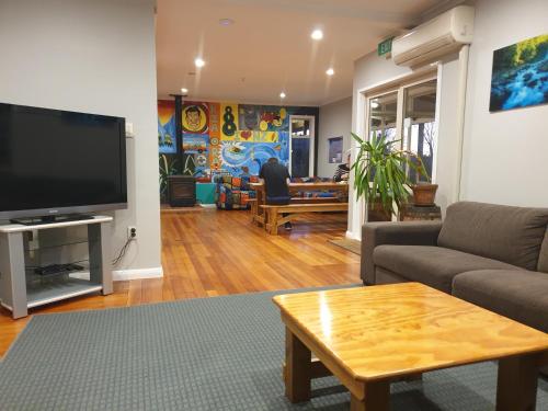 a living room with a couch and a tv at Plateau Lodge in National Park