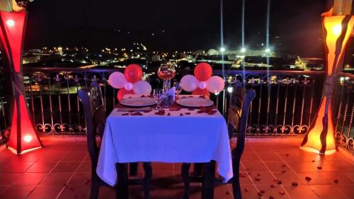 a table with balloons on a balcony at night at Hotel Las Rocas Resort Villanueva in Villanueva