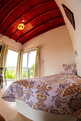 a bedroom with a large bed in front of a window at Cabañas La Emilia Apart in Valle Grande