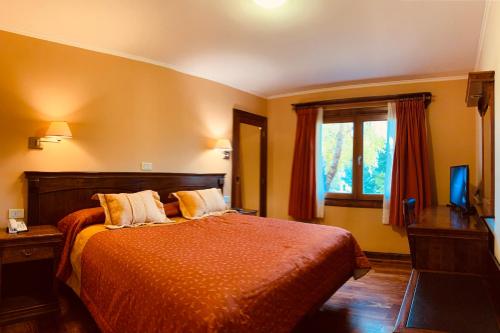 En eller flere senge i et værelse på Patagonia Queen Hotel Boutique