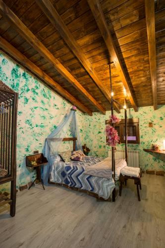 a bedroom with a canopy bed and a table at El Eden de Javier in Robledillo