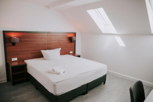 a bedroom with a large white bed with a wooden headboard at Domizil in Bremen