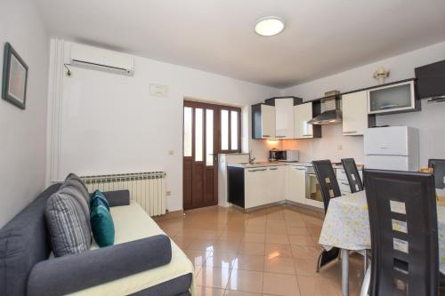 a living room with a couch and a table and a kitchen at APARTMANI MARIJA LJUBICA in Pag