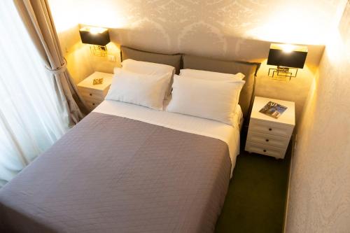 una camera con un letto con due comodini e due lampade di Cathy's Luxury Home a Roma