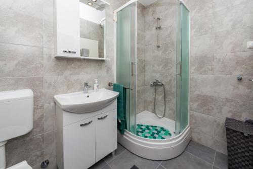 een badkamer met een douche, een wastafel en een toilet bij Korta Apartments in Viganj