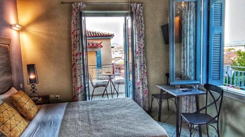 a bedroom with a bed and a balcony with a table and chairs at Porto Bello Nafplio in Nafplio