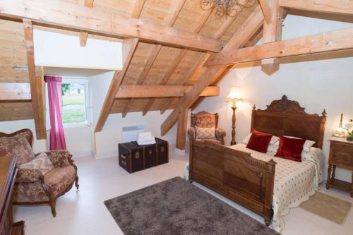 um quarto com uma cama num quarto com tectos em madeira em Maison harmonie em Buzy