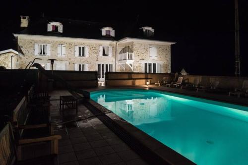 une piscine devant un immeuble la nuit dans l'établissement Maison harmonie, à Buzy