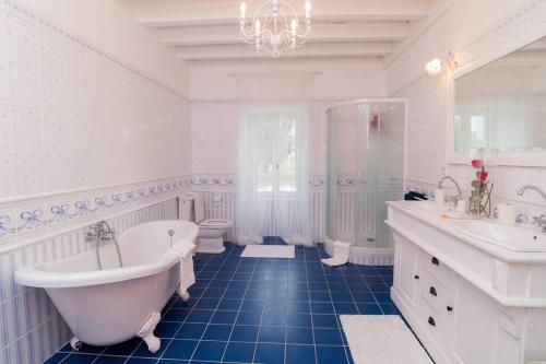 a white bathroom with a tub and a sink and a tub at Maison harmonie in Buzy