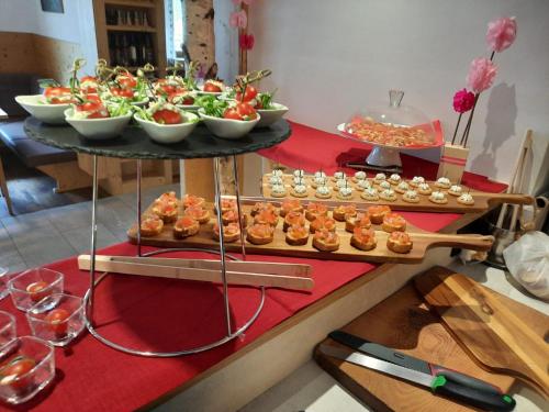 a table with a tray of food and appetizers at Hotel Gran Pre in San Vigilio Di Marebbe