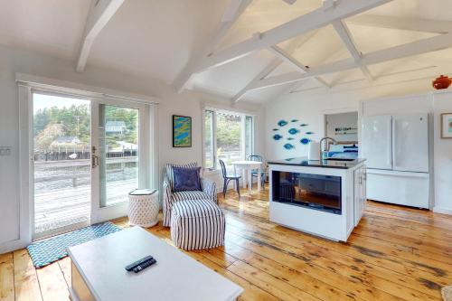 a living room with a kitchen and a living room with wooden floors at Sweet Haven in Boothbay Harbor