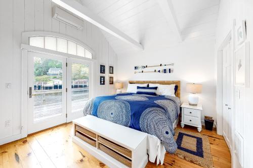 a white bedroom with a bed and a window at Sweet Haven in Boothbay Harbor
