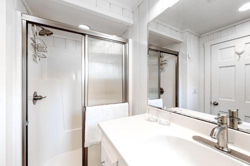 a white bathroom with a sink and a shower at Sweet Haven in Boothbay Harbor