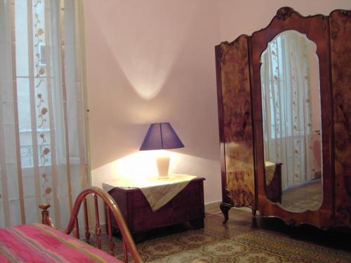 uma lâmpada sentada numa mesa ao lado de um espelho em Girasole home em Trapani